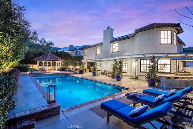 29614 Ridgeway Dr, Agoura Hills, CA 91301 - pool at dusk with a gazebo, a patio, and an outdoor pool
