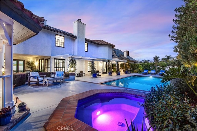 29614 Ridgeway Dr, Agoura Hills, CA 91301 - pool at dusk with an in-ground hot tub, a patio, an outdoor pool, and an outdoor living space