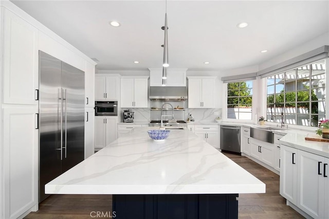 29614 Ridgeway Dr, Agoura Hills, CA 91301 - kitchen with stainless steel appliances, decorative backsplash, white cabinets, a center island, and dark wood finished floors