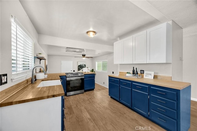 350 E Olive Ave, La Habra, CA 90631 - kitchen featuring gas stove, blue cabinets, wooden counters, and light wood-style floors