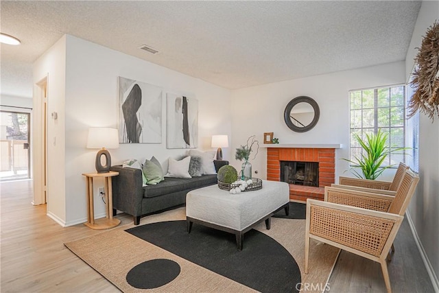 21715 Laurelrim Dr Unit D, Diamond Bar, CA 91765 - living area featuring wood finished floors, a textured ceiling, and a brick fireplace