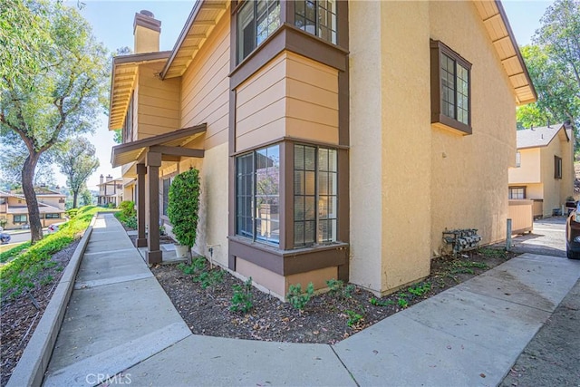 21715 Laurelrim Dr Unit D, Diamond Bar, CA 91765 - view of side of property featuring stucco siding and a chimney
