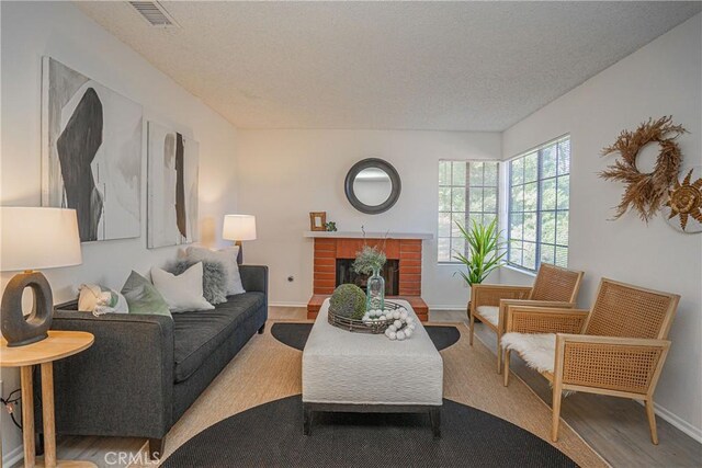 21715 Laurelrim Dr Unit D, Diamond Bar, CA 91765 - living room featuring wood finished floors, a brick fireplace, and a textured ceiling