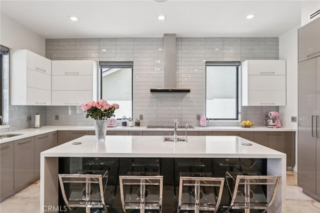 10418 Rubio Ave, Granada Hills, CA 91344 - kitchen featuring wall chimney range hood, modern cabinets, light countertops, decorative backsplash, and recessed lighting