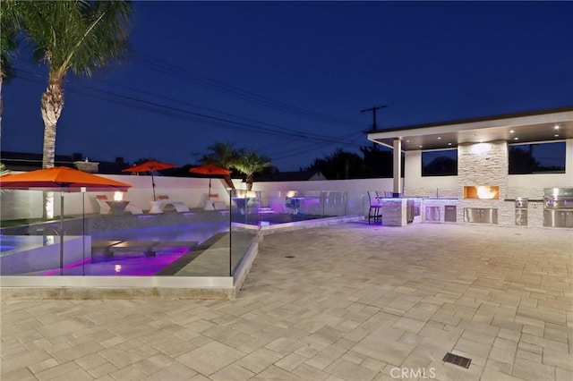 10418 Rubio Ave, Granada Hills, CA 91344 - pool at night featuring a patio area, an outdoor kitchen, and a jacuzzi