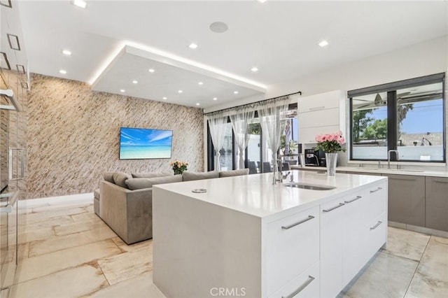 10418 Rubio Ave, Granada Hills, CA 91344 - kitchen with modern cabinets, light marble finish floors, recessed lighting, an island with sink, and white cabinetry