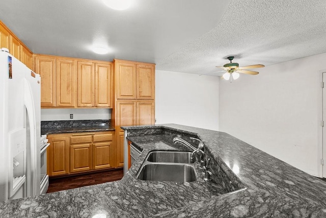 3611 S Bear St Unit K, Santa Ana, CA 92704 - kitchen featuring white fridge with ice dispenser, ceiling fan, dark wood finished floors, dark stone counters, and a textured ceiling