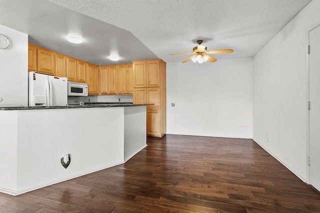 3611 S Bear St Unit K, Santa Ana, CA 92704 - kitchen with white appliances, a ceiling fan, dark countertops, dark wood finished floors, and a textured ceiling
