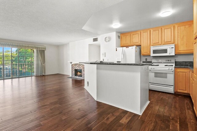 3611 S Bear St Unit K, Santa Ana, CA 92704 - kitchen featuring white appliances, dark wood finished floors, dark countertops, a fireplace, and open floor plan