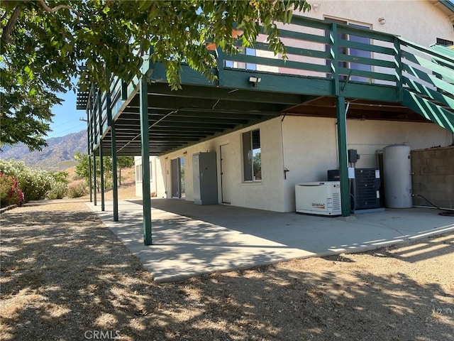 28714 Cruthers Creek Rd, Pearblossom, CA 93553 - rear view of house featuring stucco siding, a carport, a patio area, and water heater
