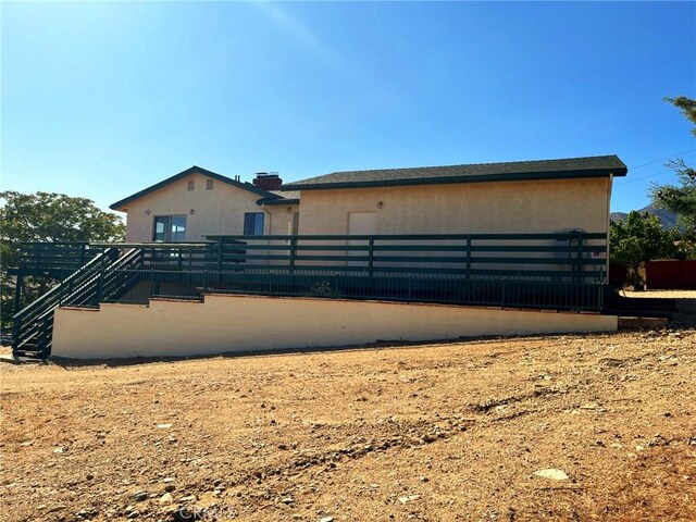 28714 Cruthers Creek Rd, Pearblossom, CA 93553 - rear view of property with stairway and stucco siding