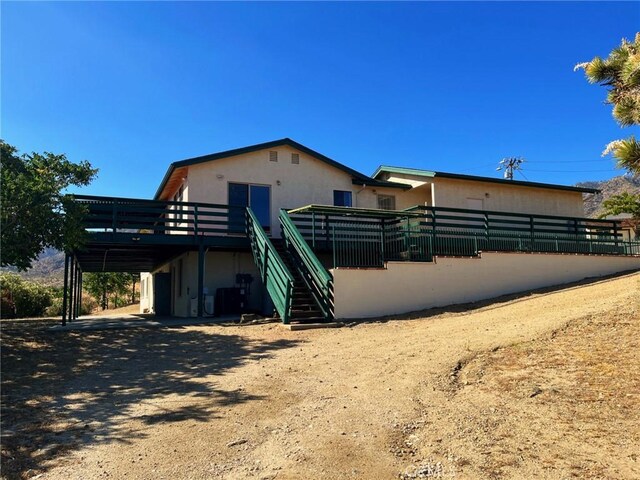 28714 Cruthers Creek Rd, Pearblossom, CA 93553 - view of front of home with a deck, stucco siding, and stairs