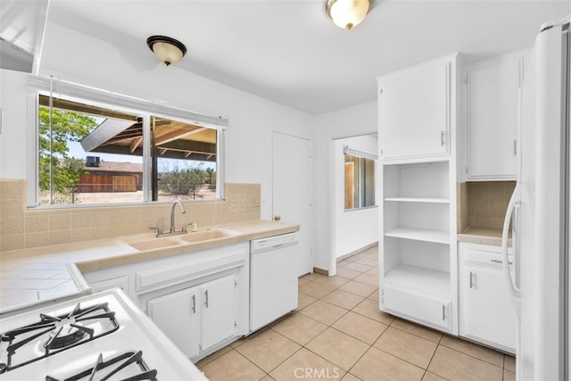 7535 Hilton Ave, Yucca Valley, CA 92284 - kitchen with white appliances, white cabinetry, decorative backsplash, light tile patterned flooring, and tile countertops