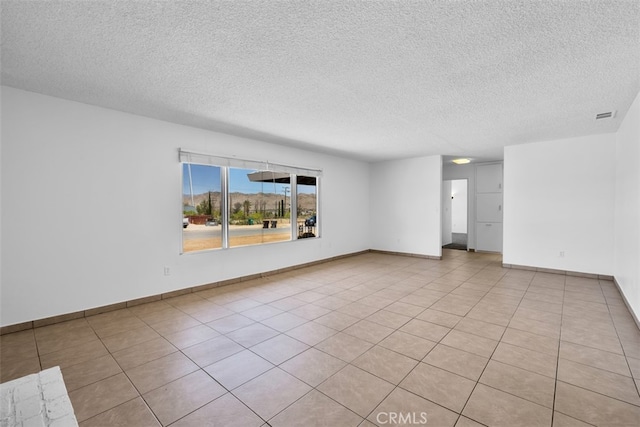 7535 Hilton Ave, Yucca Valley, CA 92284 - empty room with a textured ceiling and light tile patterned floors