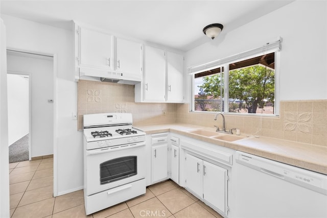 7535 Hilton Ave, Yucca Valley, CA 92284 - kitchen with white appliances, under cabinet range hood, light tile patterned flooring, and white cabinetry