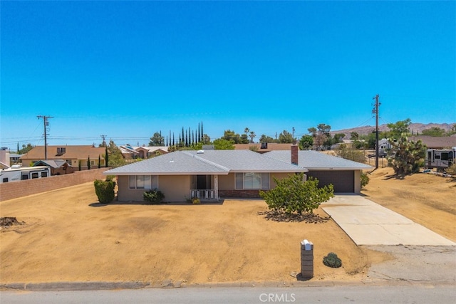 7535 Hilton Ave, Yucca Valley, CA 92284 - single story home with concrete driveway, a garage, and a chimney