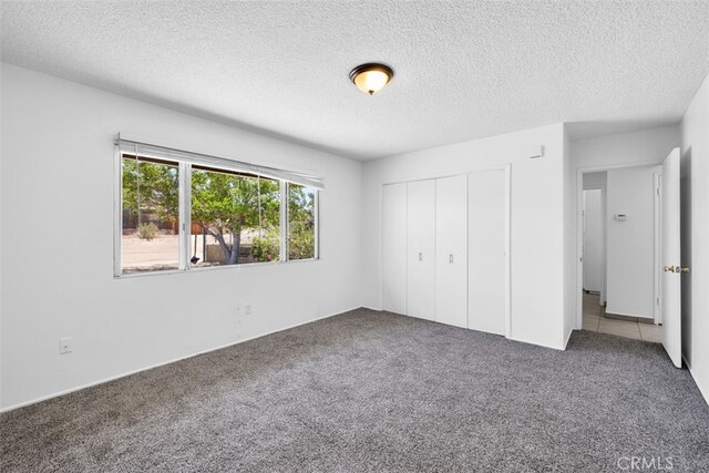 7535 Hilton Ave, Yucca Valley, CA 92284 - unfurnished bedroom featuring carpet, a textured ceiling, and a closet