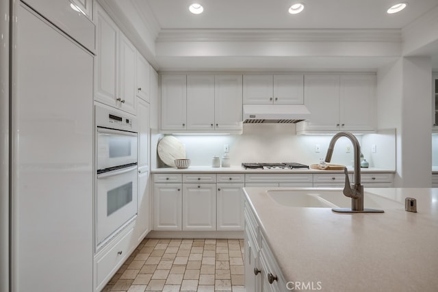 2569 Bungalow Pl, Corona Del Mar, CA 92625 - kitchen featuring white double oven, ornamental molding, light countertops, white cabinets, and recessed lighting