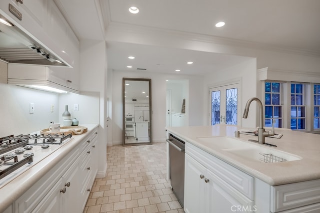 2569 Bungalow Pl, Corona Del Mar, CA 92625 - kitchen with under cabinet range hood, white gas stovetop, stainless steel dishwasher, white cabinetry, and crown molding