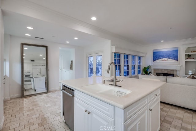 2569 Bungalow Pl, Corona Del Mar, CA 92625 - kitchen featuring dishwasher, open floor plan, a tiled fireplace, white cabinetry, and recessed lighting