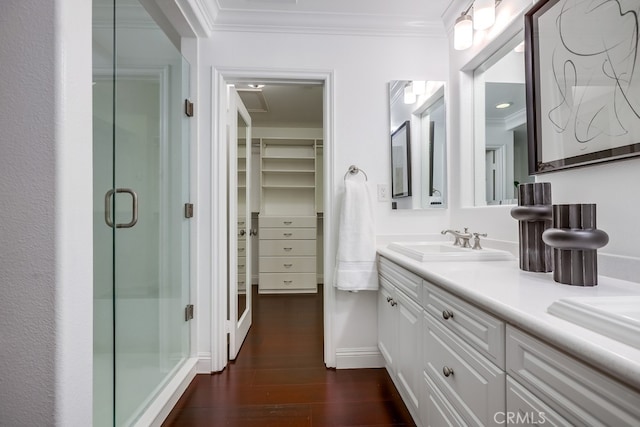 2569 Bungalow Pl, Corona Del Mar, CA 92625 - bathroom with crown molding, a stall shower, double vanity, a walk in closet, and wood finished floors