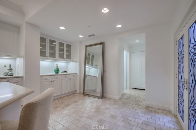 2569 Bungalow Pl, Corona Del Mar, CA 92625 - kitchen with white cabinets, recessed lighting, glass insert cabinets, light countertops, and brick patterned flooring