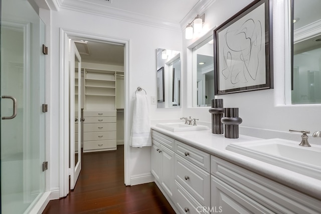 2569 Bungalow Pl, Corona Del Mar, CA 92625 - bathroom with ornamental molding, double vanity, a shower stall, wood finished floors, and a spacious closet