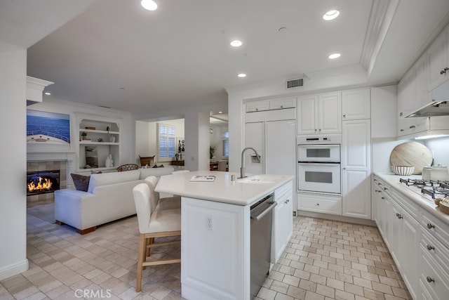 2569 Bungalow Pl, Corona Del Mar, CA 92625 - kitchen featuring white appliances, light countertops, a fireplace, white cabinetry, and open floor plan