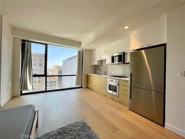 400 S Broadway Unit 1202, Los Angeles, CA 90013 - kitchen featuring stainless steel appliances, light wood-type flooring, white cabinets, light countertops, and recessed lighting