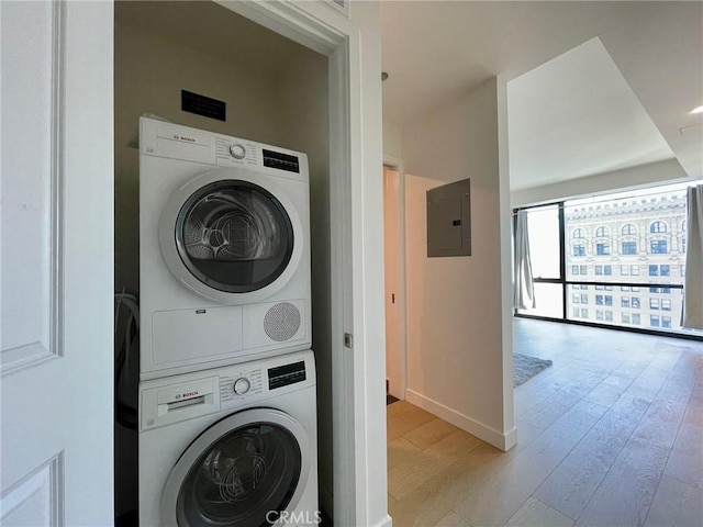 400 S Broadway Unit 1202, Los Angeles, CA 90013 - laundry room featuring stacked washer and clothes dryer, electric panel, and light wood-type flooring