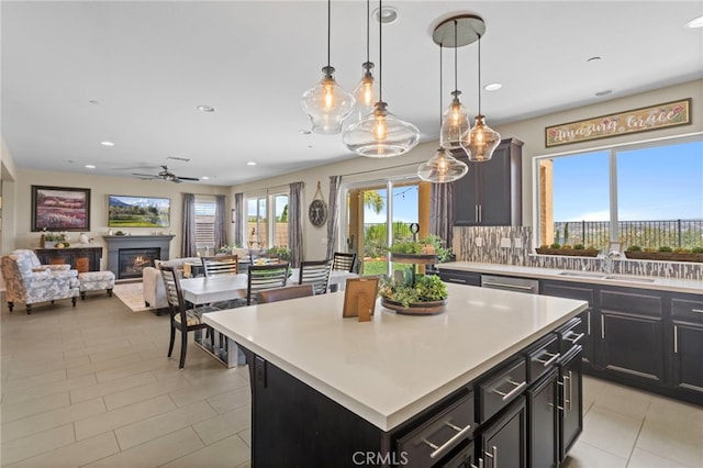 44316 Revana St, Temecula, CA 92592 - kitchen featuring a ceiling fan, recessed lighting, light countertops, light tile patterned floors, and a glass covered fireplace