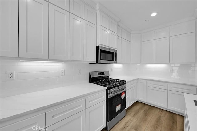 5350 Filbert St, Paradise, CA 95969 - kitchen with stainless steel appliances, white cabinets, tasteful backsplash, light wood-style flooring, and recessed lighting