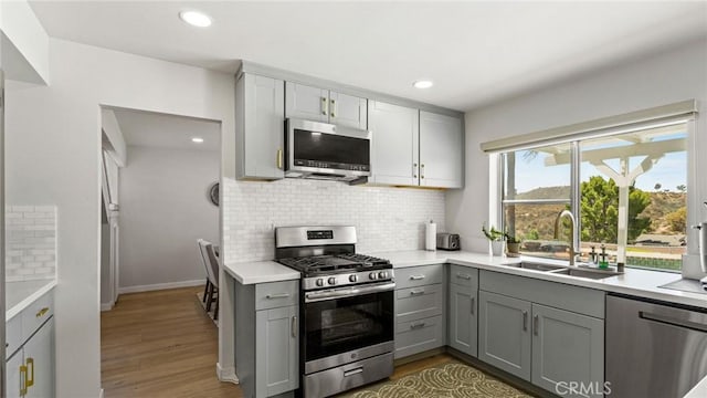 23208 Cuervo Dr, Valencia, CA 91354 - kitchen with appliances with stainless steel finishes, gray cabinetry, tasteful backsplash, light countertops, and recessed lighting