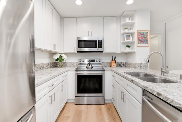 4600 Lamont St Unit 106, San Diego, CA 92109 - kitchen with stainless steel appliances, recessed lighting, light wood-style floors, white cabinets, and open shelves