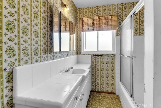 57136 Navajo Trl, Yucca Valley, CA 92284 - bathroom with wallpapered walls, vanity, and combined bath / shower with glass door