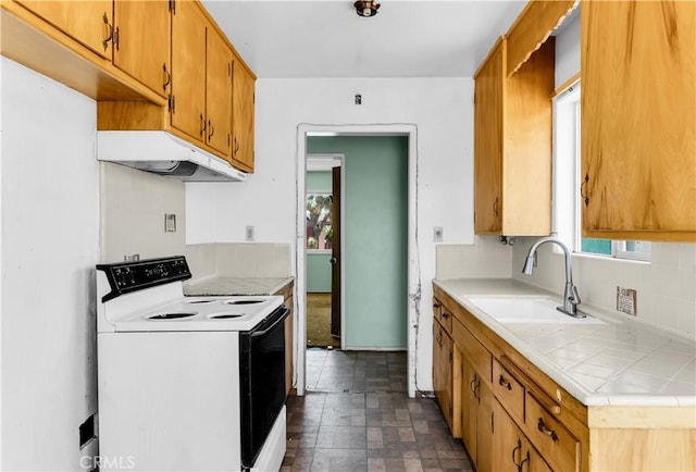 57136 Navajo Trl, Yucca Valley, CA 92284 - kitchen featuring electric range, under cabinet range hood, tile countertops, dark stone finish flooring, and backsplash