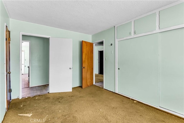 57136 Navajo Trl, Yucca Valley, CA 92284 - unfurnished bedroom with carpet flooring, a textured ceiling, and a closet