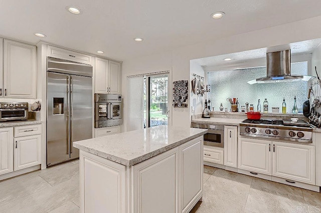 4014 Aguila St Unit F, Carlsbad, CA 92008 - kitchen with stainless steel appliances, wall chimney range hood, recessed lighting, white cabinets, and a kitchen island