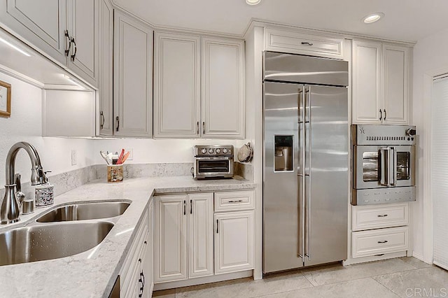 4014 Aguila St Unit F, Carlsbad, CA 92008 - kitchen with appliances with stainless steel finishes, light tile patterned floors, and light stone counters