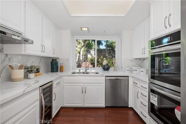 9 Aberdeen St, Irvine, CA 92620 - kitchen with beverage cooler, stainless steel appliances, range hood, white cabinets, and tasteful backsplash