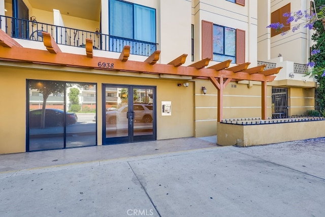 6938 Laurel Canyon Blvd Unit 101, North Hollywood, CA 91605 - doorway to property featuring french doors, stucco siding, and a pergola