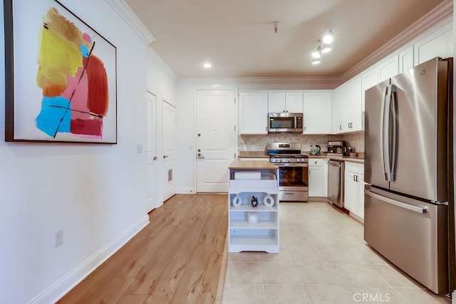 6938 Laurel Canyon Blvd Unit 101, North Hollywood, CA 91605 - kitchen featuring appliances with stainless steel finishes, crown molding, white cabinets, open shelves, and tasteful backsplash
