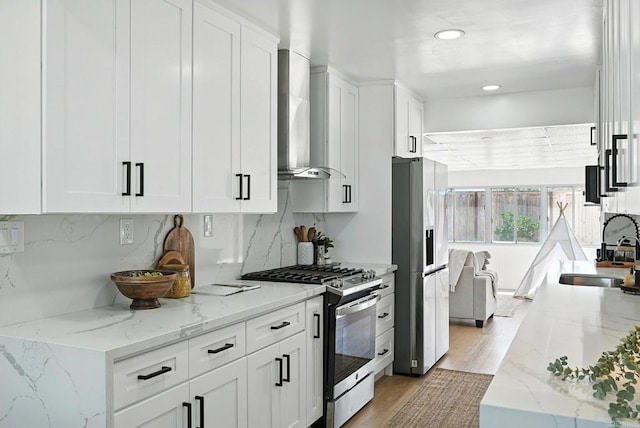 4862 Kesling Ct, San Diego, CA 92117 - kitchen with appliances with stainless steel finishes, wall chimney exhaust hood, tasteful backsplash, white cabinetry, and recessed lighting
