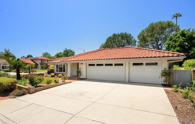 1879 Falconer Ct, Vista, CA 92081 - mediterranean / spanish house with a garage, driveway, a tiled roof, and stucco siding