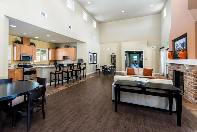 10667 Golden Willow Unit 152, San Diego, CA 92130 - living room with a high ceiling, dark wood-style floors, recessed lighting, and a fireplace