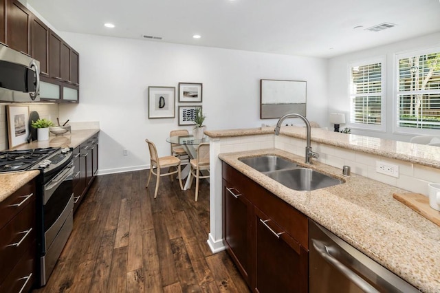 10667 Golden Willow Unit 152, San Diego, CA 92130 - kitchen with stainless steel appliances, dark wood finished floors, tasteful backsplash, dark brown cabinetry, and light stone counters
