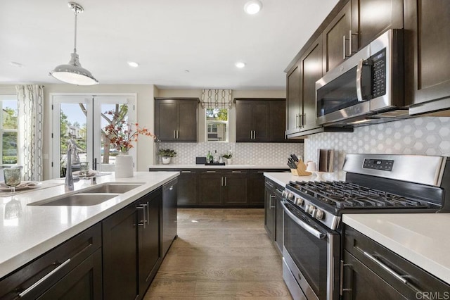 16755 Coyote Bush Dr Unit 15, San Diego, CA 92127 - kitchen with appliances with stainless steel finishes, dark brown cabinets, light wood finished floors, light countertops, and backsplash