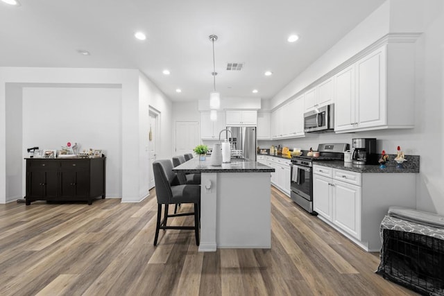 1925 Avenida Senecio Unit 2, Chula Vista, CA 91913 - kitchen featuring appliances with stainless steel finishes, white cabinets, light wood-type flooring, a kitchen breakfast bar, and recessed lighting