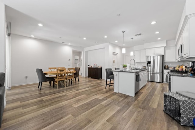 1925 Avenida Senecio Unit 2, Chula Vista, CA 91913 - kitchen featuring appliances with stainless steel finishes, dark countertops, recessed lighting, light wood finished floors, and white cabinets