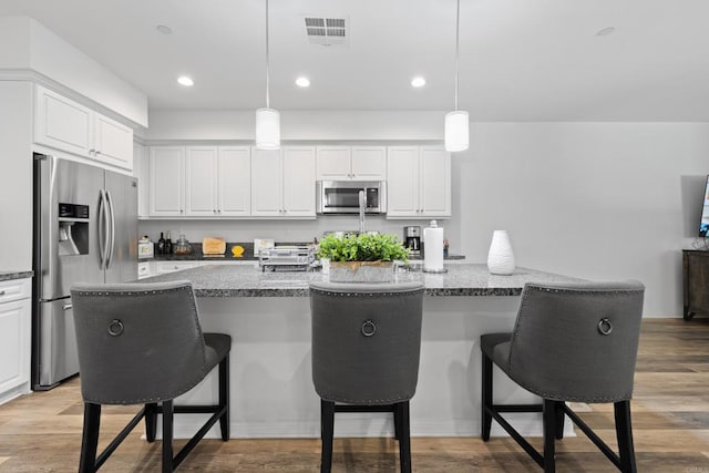 1925 Avenida Senecio Unit 2, Chula Vista, CA 91913 - kitchen featuring appliances with stainless steel finishes, a breakfast bar area, white cabinets, decorative light fixtures, and recessed lighting